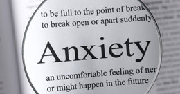 A photo of a magnifying glass enlarging the word anxiety in a dictionary which links to the talking cures contact page